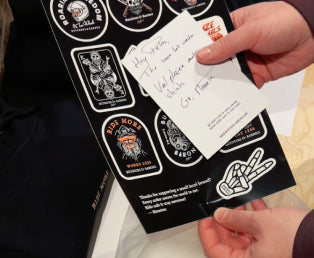 Person holding a thank you note and stickers from Butchers & Barons